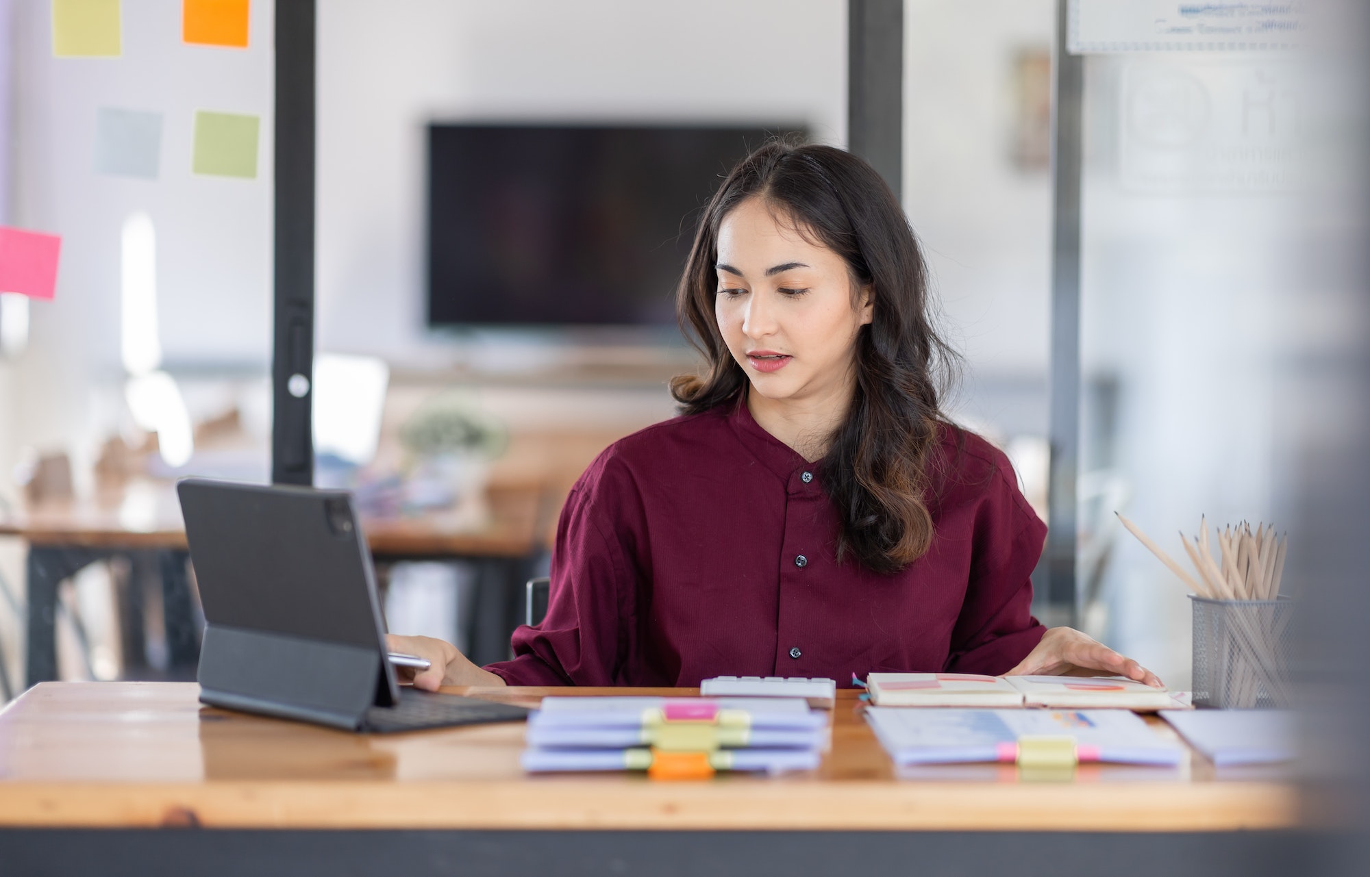 Business female employee with many conflicting priorities arranging sticky notes commenting